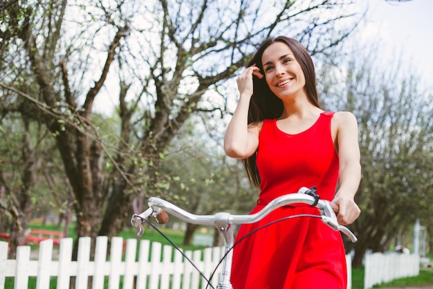 Beautiful smiling girl is riding the bicycle in the park