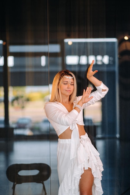 Beautiful smiling girl in a white dress dancing in the gym