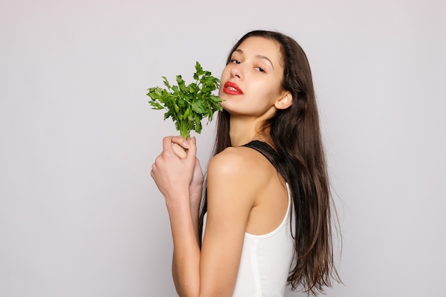 beautiful smiling girl with parsley photo of fashion female on gray background