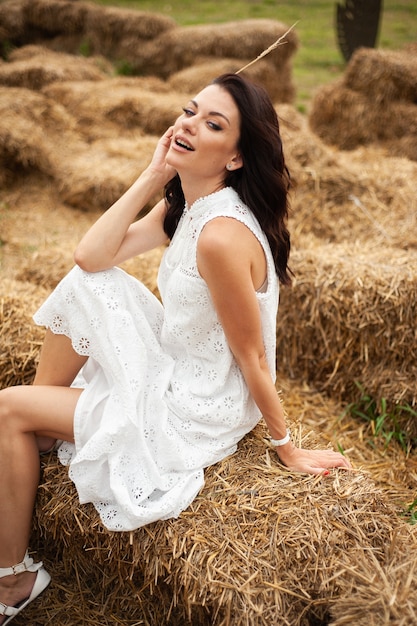 Beautiful smiling woman on dry grass