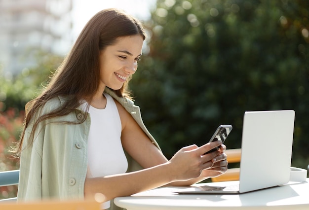 Beautiful smiling woman holding smartphone and shopping online at the mobile app