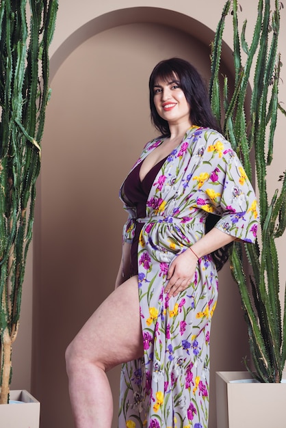 Beautiful smiling woman in a light silk tunic for the beach