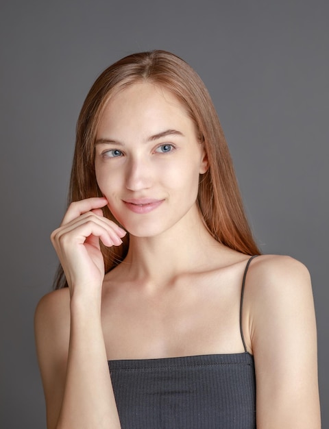 Beautiful smiling young woman with perfect skin face natural beauty concept isolated on studio background