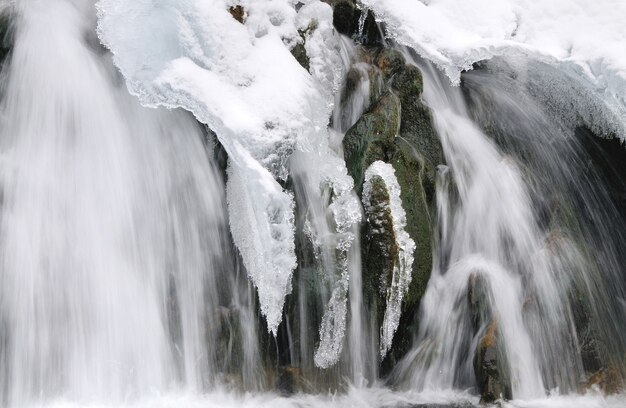 Beautiful snowy waterfall flowing in the mountains