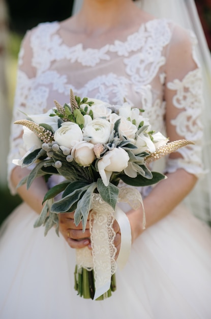 Beautiful and sophisticated wedding bouquet close-up holds the bride in her hands. Wedding bouquet.