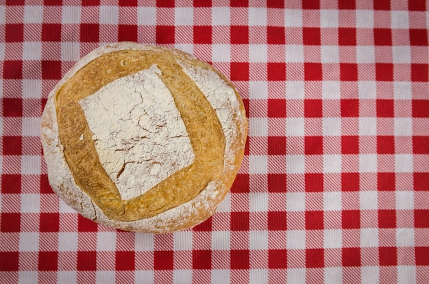 Beautiful Sourdough bread being held by woman's hands and blurred background