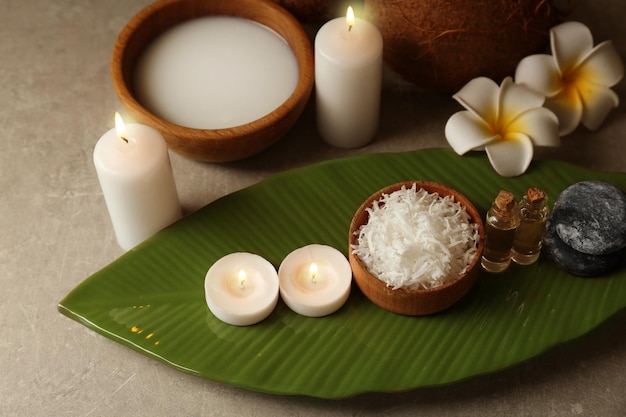 Beautiful spa composition with coconut body care products and candles on table