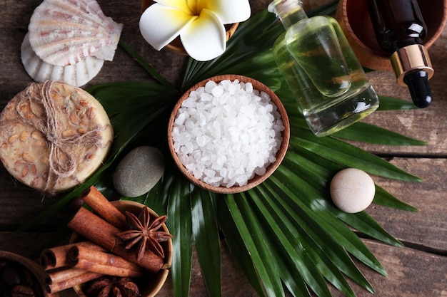 Beautiful spa setting on palm leaf on wooden table