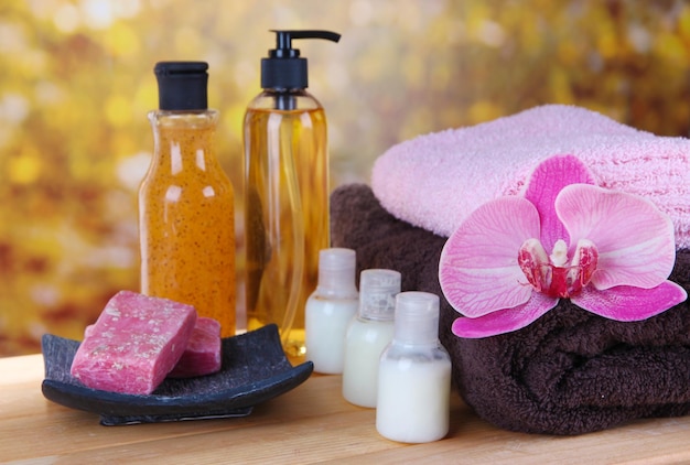 Beautiful spa setting with flower on wooden table on bright background