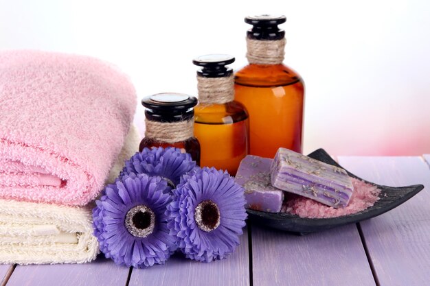 Beautiful spa setting with flowers on wooden table on bright background