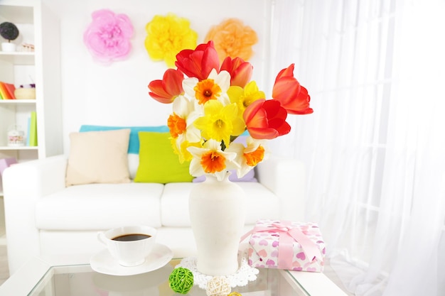 Beautiful spring flowers in vase on home interior background