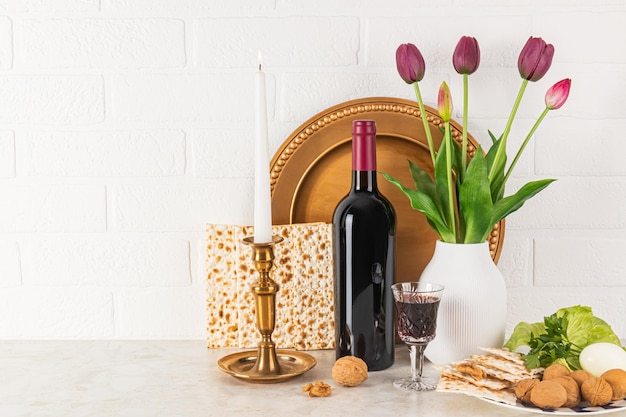 Beautiful still life for the spring holiday of Jewish Passover Front view of traditional products for holiday matzoth bottle of red wine dish