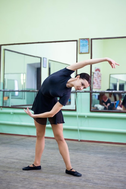 Beautiful student dancer warming up before lesson of choreography Professional dancer student learning new moves