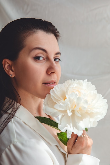 Beautiful stunning woman with peonies flowers. close up