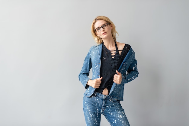 Beautiful stylish blonde model in jeans suit posing