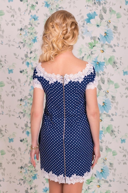 Beautiful and stylish blue polka dot dress on flowers background