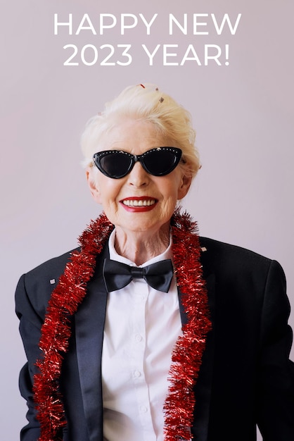 Beautiful stylish mature senior woman in sunglasses and tuxedo celebrating new year. Fun, party