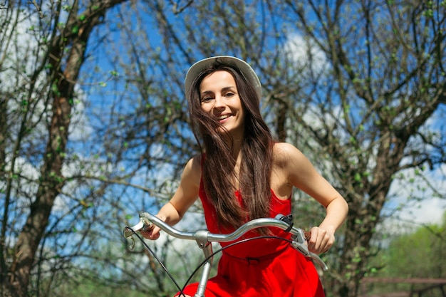 Beautiful stylish woman with blue retro bike posing outdoors and have fun