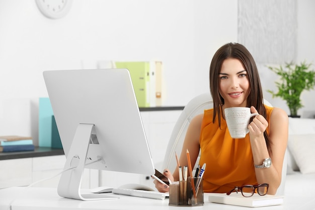 A beautiful successful woman drinking coffee at the modern office