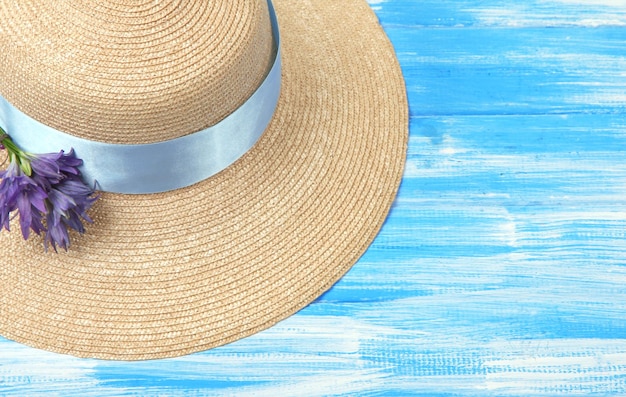 Beautiful summer hat on blue wooden background