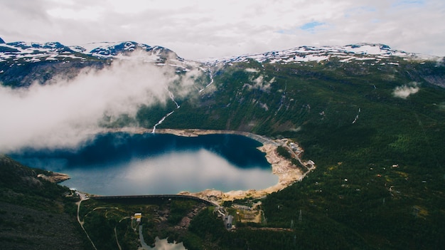 Photo beautiful summer vibrant view on famous norwegian tourist place - trolltunga, the trolls tongue with a lake and mountains, norway, odda.