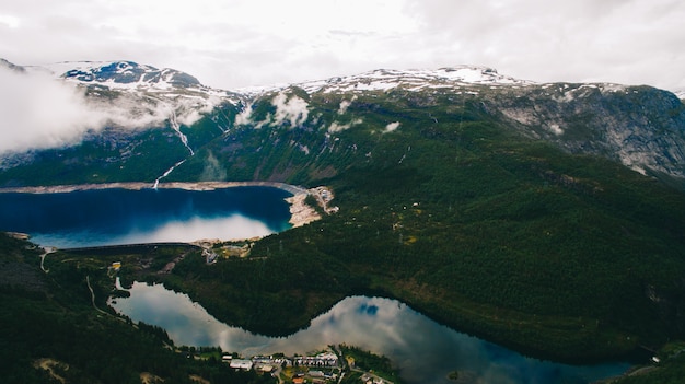 Beautiful summer vibrant view on famous Norwegian tourist place - trolltunga, the trolls tongue with a lake and mountains, Norway, Odda.