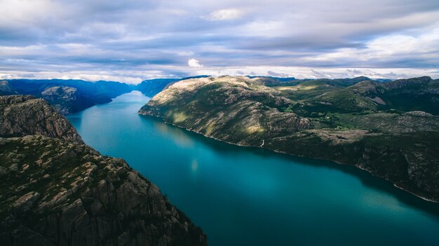 Photo beautiful summer vibrant view on famous norwegian tourist place - trolltunga, the trolls tongue with a lake and mountains, norway, odda.