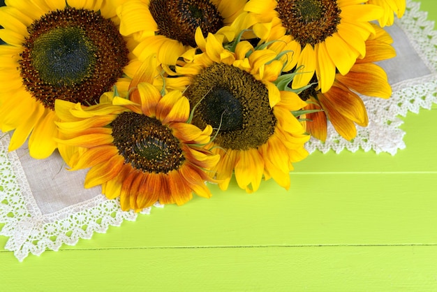 Beautiful sunflowers in pitcher on napkin on table close up