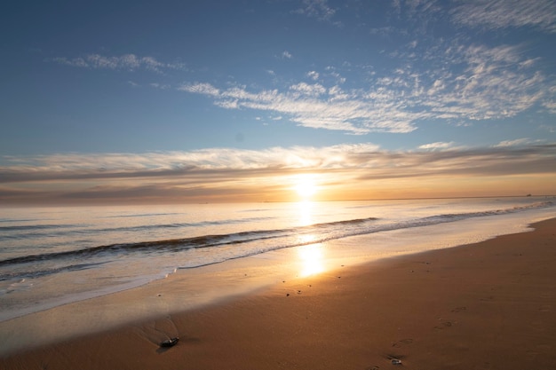 A beautiful sunset on the beach of Mazagon Spain In the background the silhouettes of two surfers