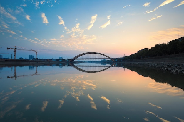 Beautiful sunset glow and bridge reflection in river