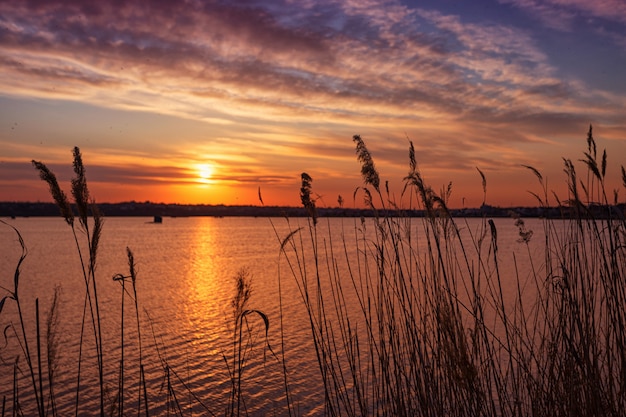 Beautiful sunset on the lake with clouds and reflections on the water