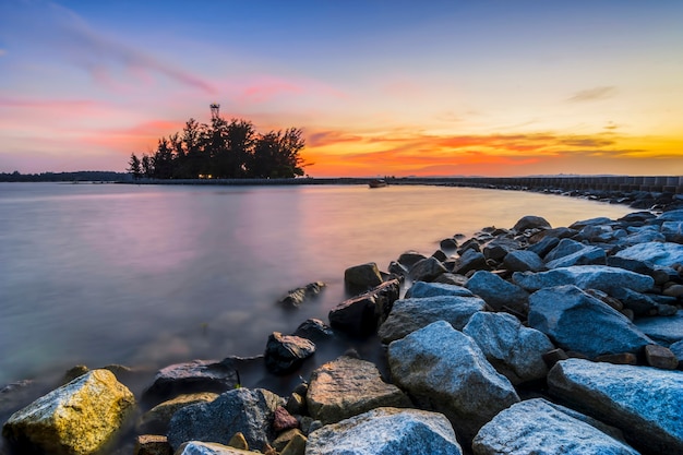 Beautiful sunset on Putri island with beautiful pier and breakwater along the beach