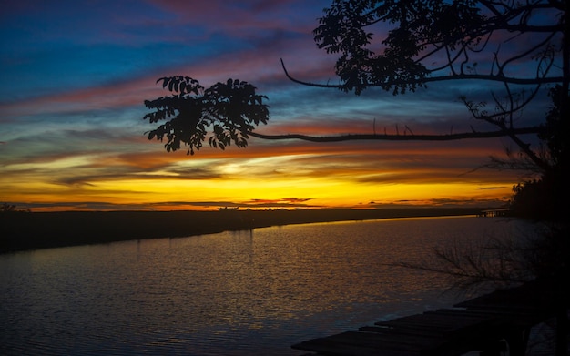 Beautiful sunset at river with silhouette of trees