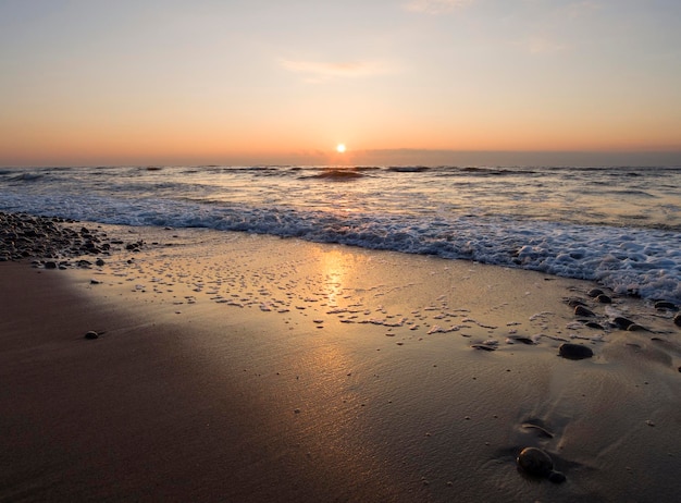 Beautiful sunset on the sandy beach of the Baltic Sea in Lietva Klaipeda