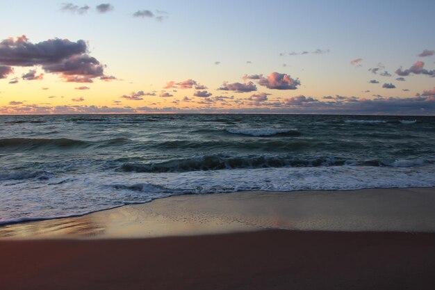 beautiful sunset over the sea with orange reflexes on clouds large format