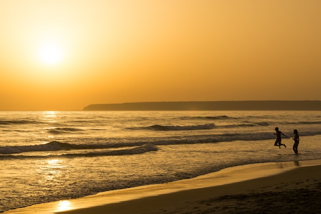 Beautiful sunset seascape with people silhouette