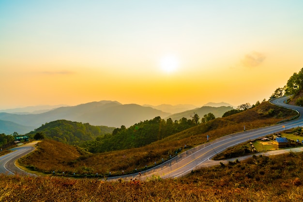 beautiful sunset sky with layer mountain and road