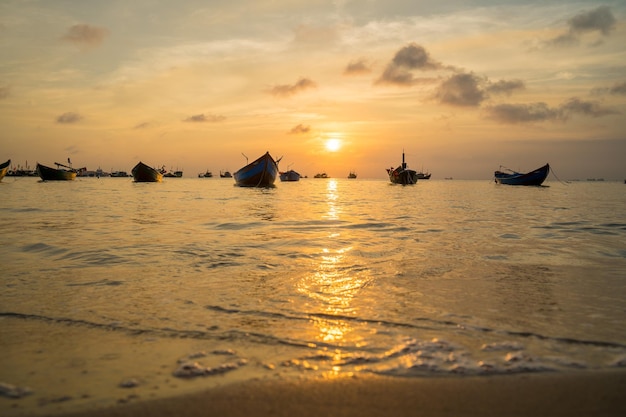 Beautiful sunset Tropical Seascape with a boat on sandy beach at cloudy