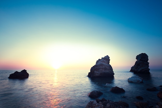 Beautiful sunset over wavy stormy Black sea rocky coastline in Crimea on summer day