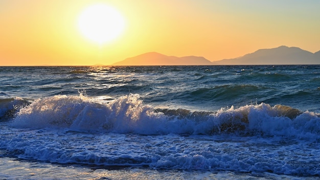 Beautiful sunset with sea and waves Natural colorful background Concept for summer and sea vacation Greece island of Kos