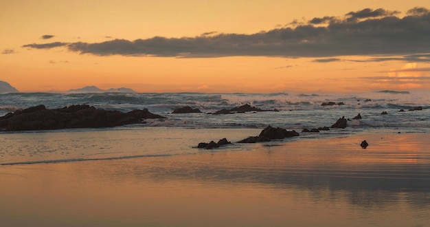 Beautiful sunset with waves in the sea and clouds in the background