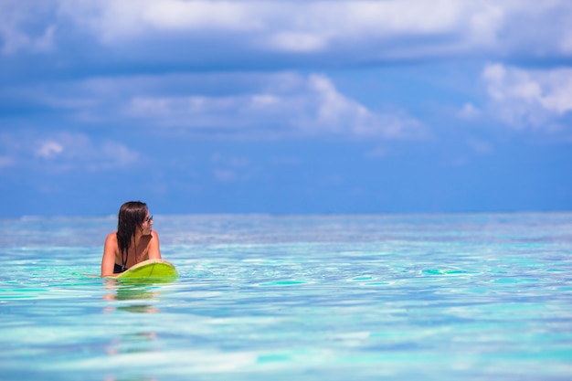 Beautiful surfer woman surfing during summer vacation