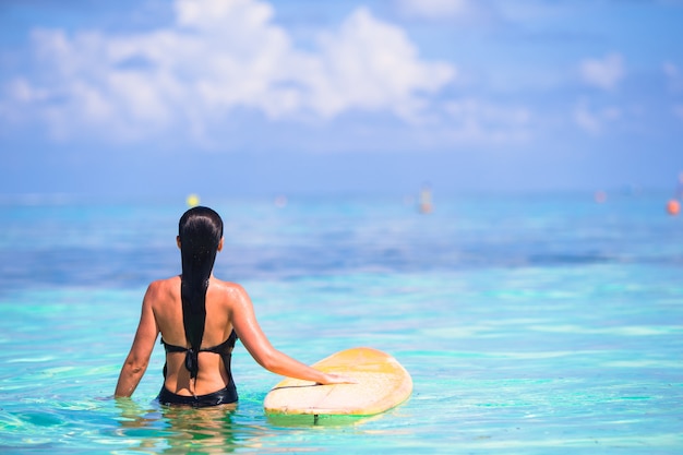 Beautiful surfer woman surfing during summer vacation