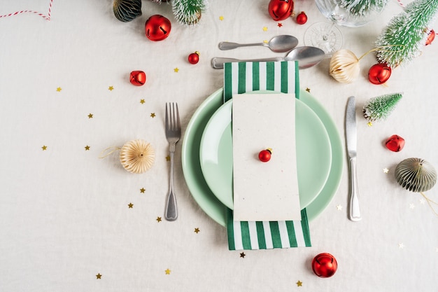 Beautiful table setting on grey background with white plates, cutlery silverware and Christmas decorations