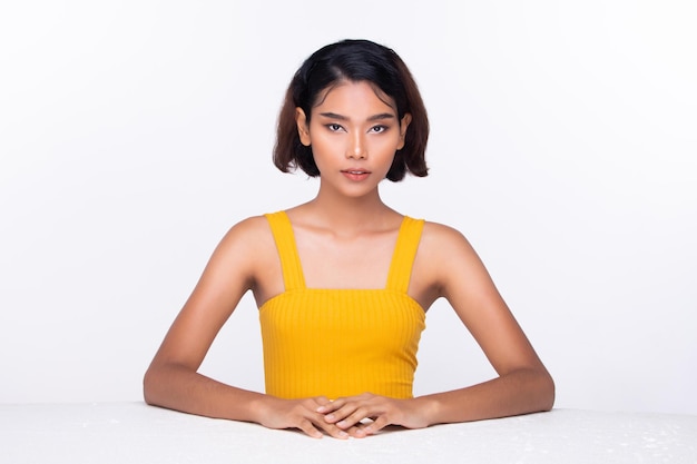 Beautiful Tanned skin woman wear yellow dress open shoulder with clean look make up and curl hair Portrait young girl in attractive natural fashion face express feel smile isolated white background