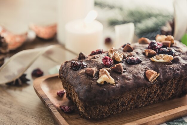 Beautiful tasty dried mixed nut Christmas fruit cake on wooden table 