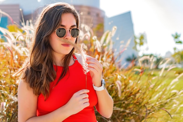 Beautiful teen looking at camera walking in a city park on spring day