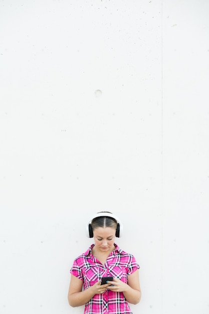 Beautiful teenager girl listening music on headphones with copy space