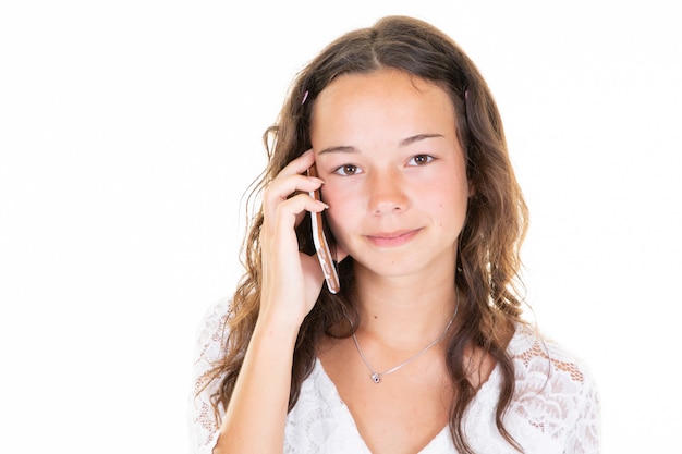 Beautiful teenager young girl talking on the phone in the Studio in white background