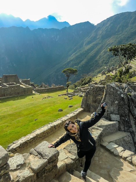 beautiful tourist with open arms in the ruins of Machu Picchu, cusco - peru